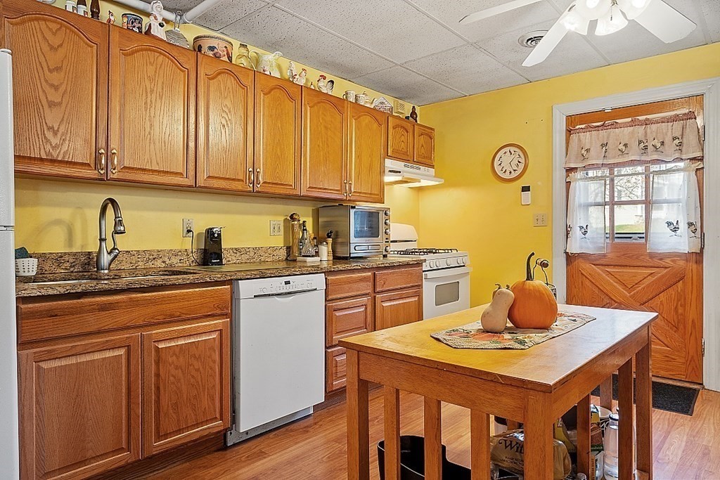 479-483 Gleasondale Road Stow, MA 01775 - Photo 23 of 40 a kitchen with stainless steel appliances granite countertop a table chairs in it and wooden floors