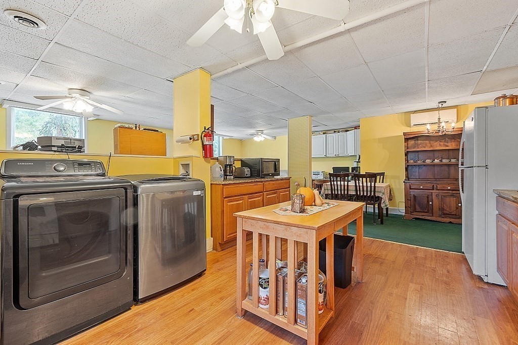 479-483 Gleasondale Road Stow, MA 01775 - Photo 24 of 40 a kitchen with stainless steel appliances kitchen island granite countertop a table chairs and a refrigerator