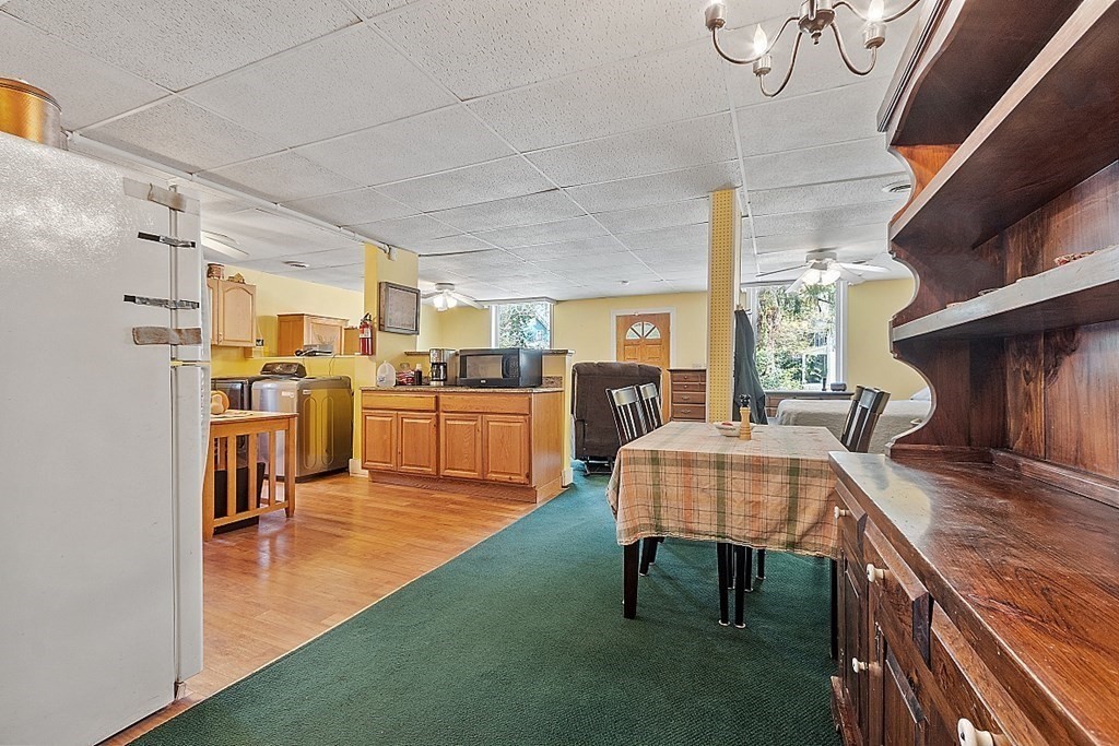 479-483 Gleasondale Road Stow, MA 01775 - Photo 28 of 40 a living room with couches chairs and kitchen view with wooden floor