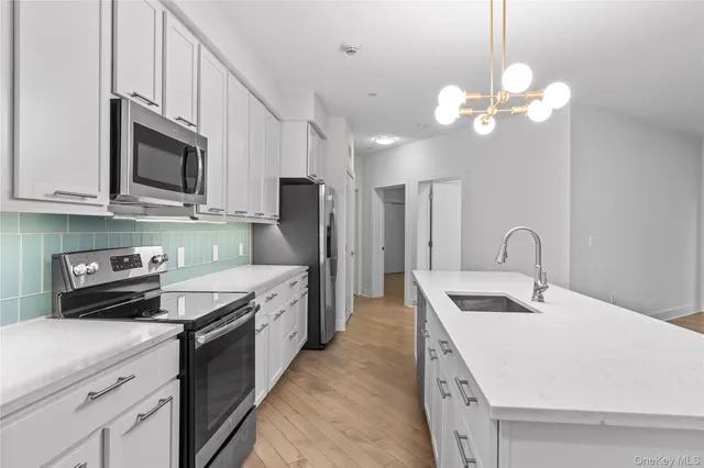 a kitchen with stainless steel appliances a stove refrigerator and microwave