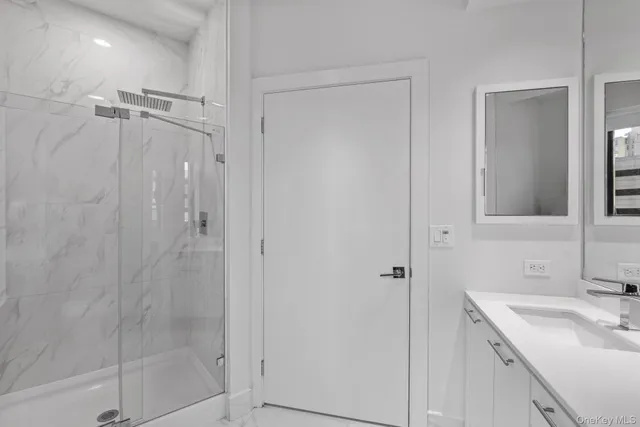 a bathroom with a shower sink vanity and mirror