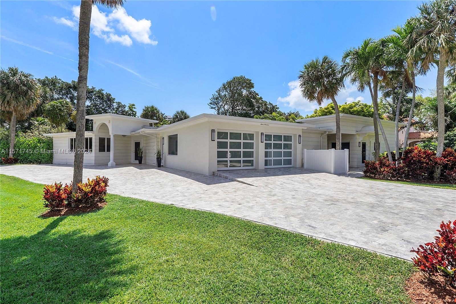 1200 Cocoanut Road Boca Raton, FL 33432 - Photo 1 of 25 a front view of a house with a yard and garage