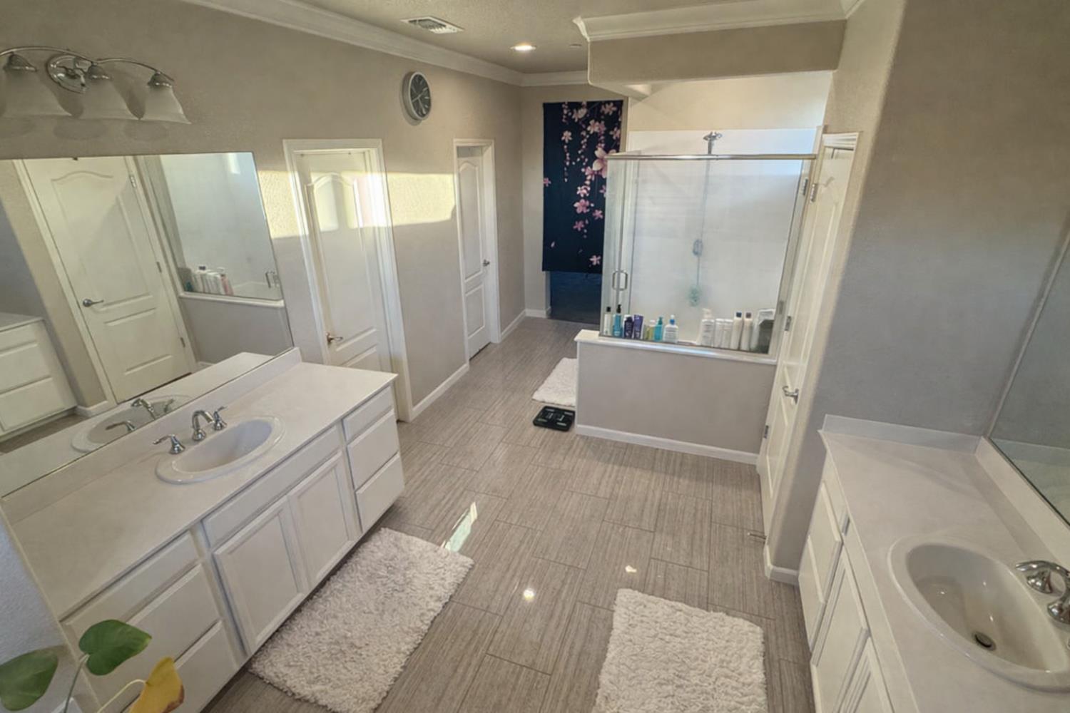 2557 Creek Hollow Road Rocklin, CA 95765 - Photo 16 of 27 a bathroom with a tub sink a mirror and shower