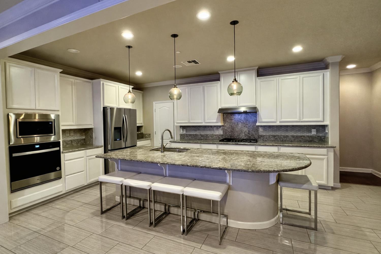 2557 Creek Hollow Road Rocklin, CA 95765 - Photo 10 of 27 a kitchen with stainless steel appliances granite countertop table chairs sink and refrigerator