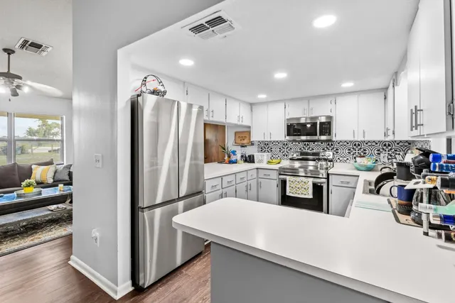 a kitchen with refrigerator cabinets and wooden floor