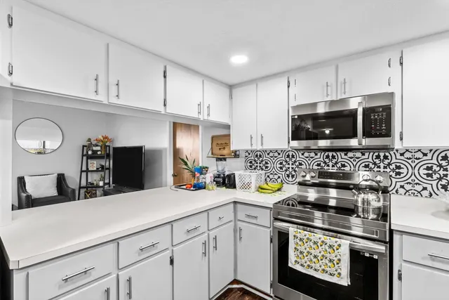 a kitchen with white cabinets and sink