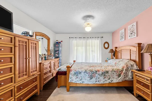 a bedroom with a bed and a large mirror with a dresser