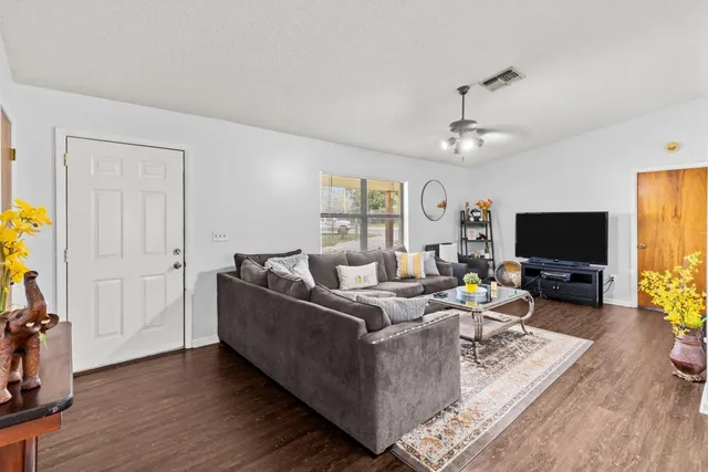 a living room with furniture a flat screen tv and a window