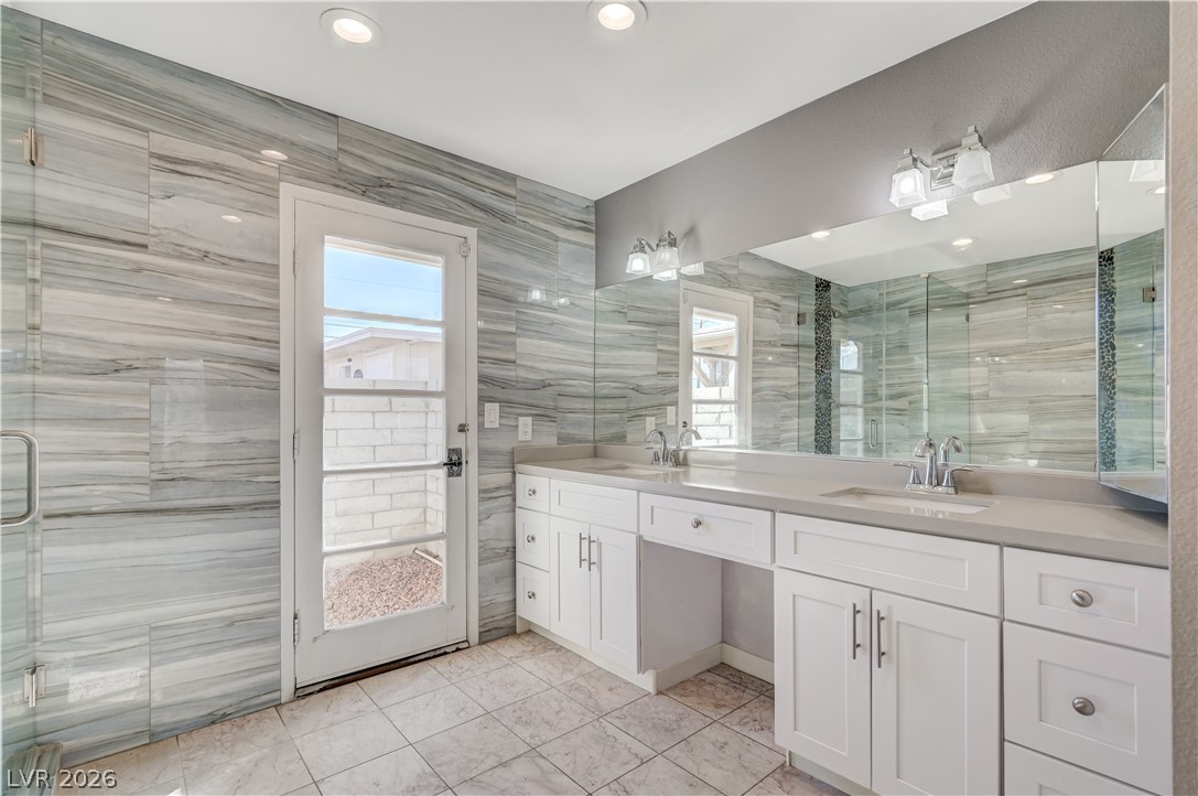 6635 Costa Brava Road Las Vegas, NV 89146 - Photo 29 of 59 Elegant primary bath with a spacious double vanity and a glass-enclosed shower.