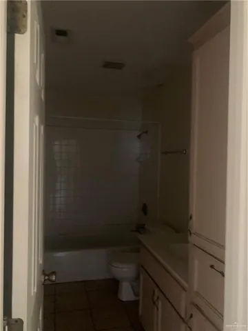 a bathroom with a granite countertop toilet and sink