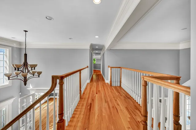 a view of a hallway with wooden floor and stairs