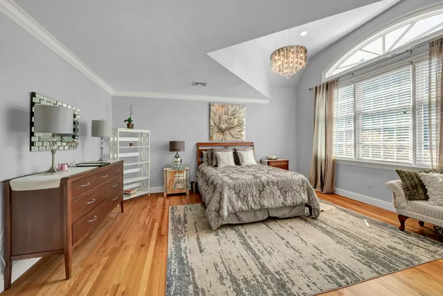 a spacious bedroom with a bed a dresser and next to a window