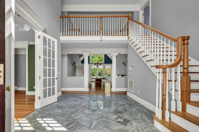 a view of a hallway with wooden floor and staircase