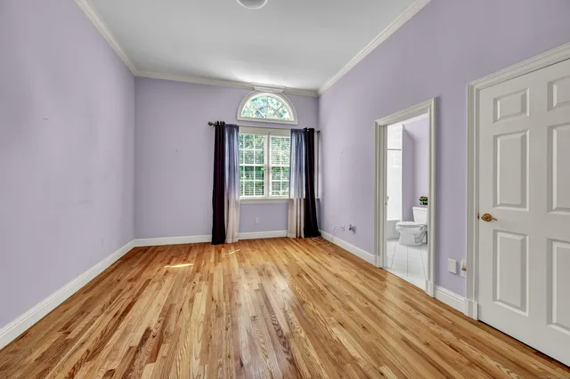 a view of an empty room with glass door and wooden floor