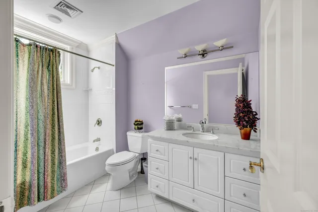 a bathroom with a granite countertop sink a toilet and a mirror