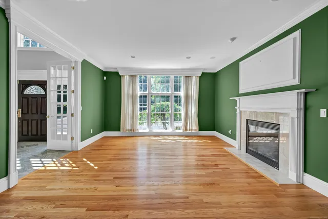a view of an empty room with window and fire place