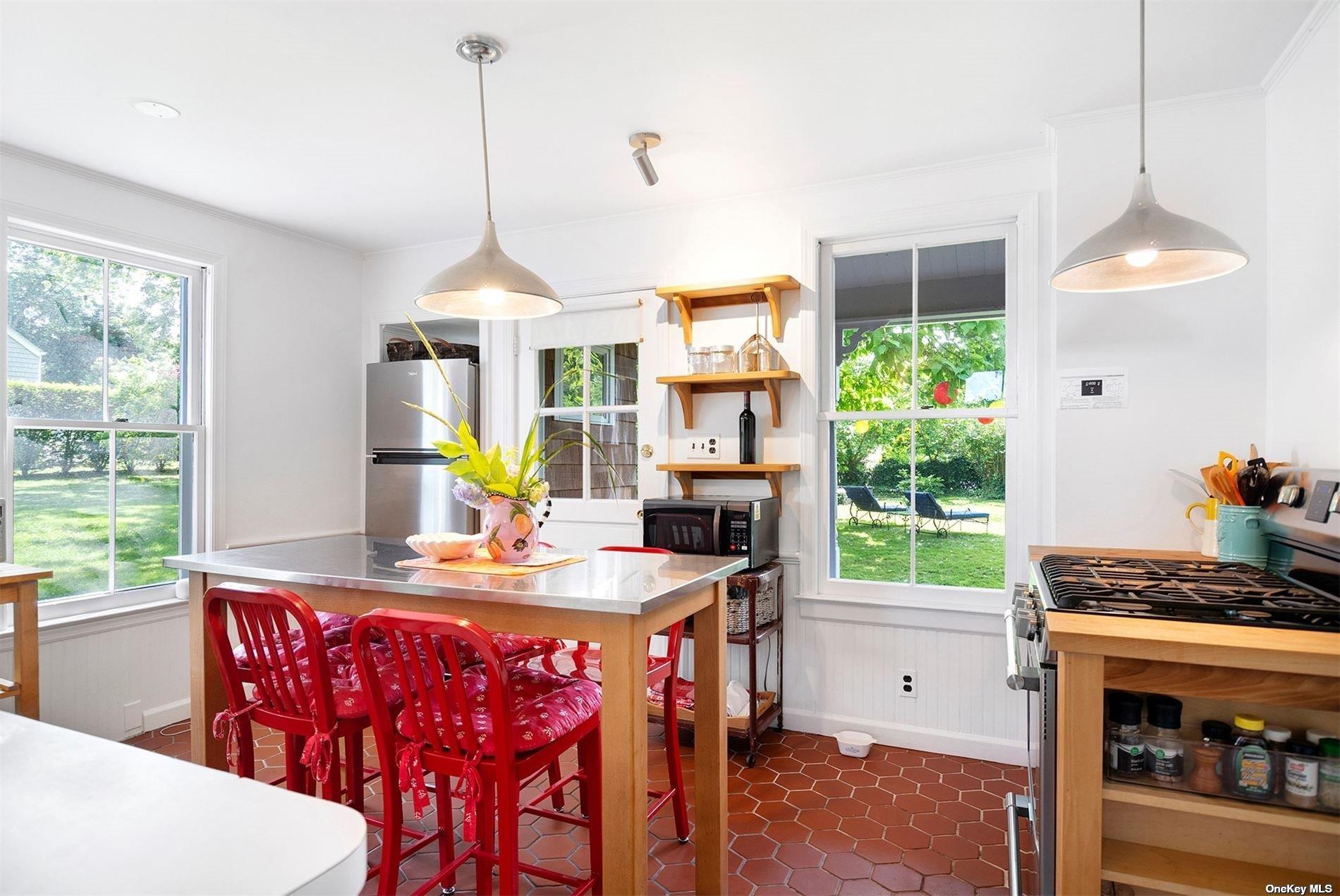 640 Orchard Street New Suffolk, NY 11956 - Photo 12 of 30 a kitchen with a stove a refrigerator and a dining table