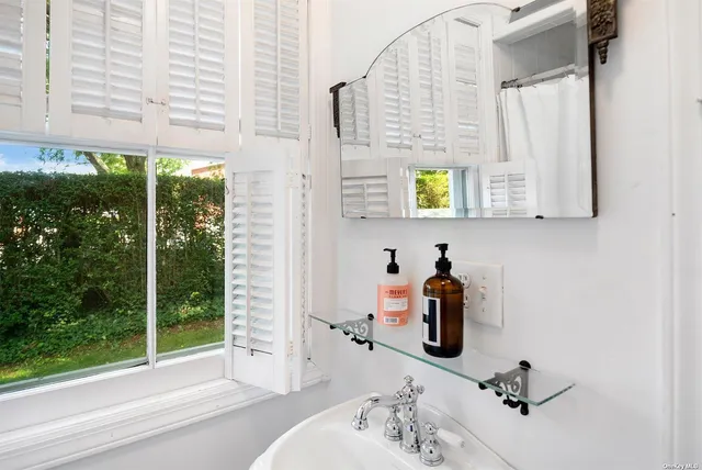 a bathroom with a window sink and mirror