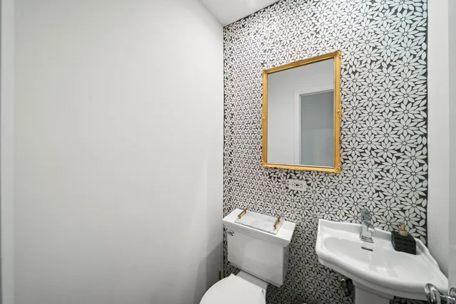 a bathroom with a toilet sink and mirror