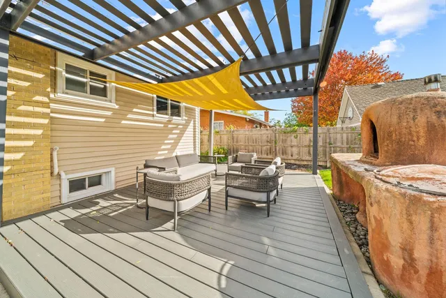 a view of a patio with couches and table and chairs with wooden floor