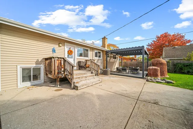 a view of a patio with table and chairs and a barbeque