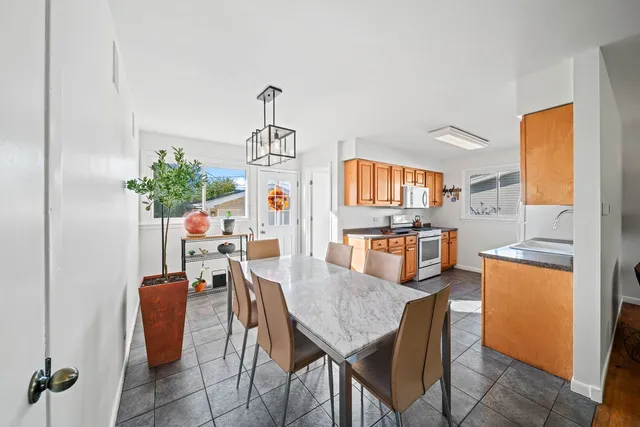 a dining room filled chandelier and wooden floor