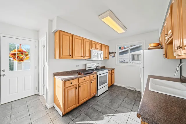a kitchen with stainless steel appliances granite countertop a sink and a refrigerator