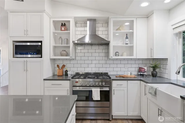 a kitchen with stainless steel appliances a stove sink and cabinets