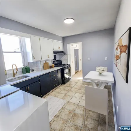 a kitchen with a stove a sink a counter top space and cabinets