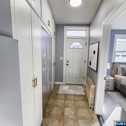 a view of a hallway with a livingroom and a mirror