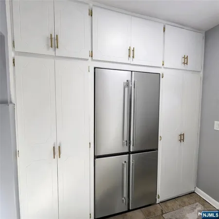 a white refrigerator freezer and cabinets in a kitchen