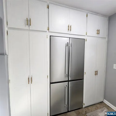 a white refrigerator freezer and cabinets in a kitchen