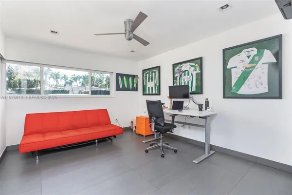 a view of a workspace with furniture and a window