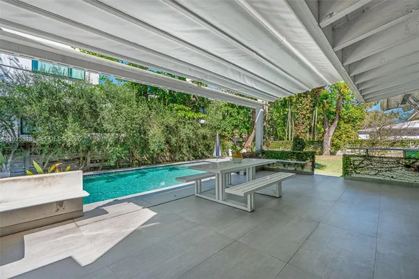 a view of yard with swimming pool and trees in the background