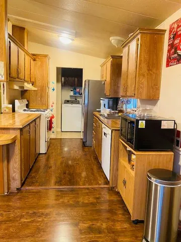 a kitchen with stainless steel appliances granite countertop a refrigerator a stove top oven a sink and dishwasher