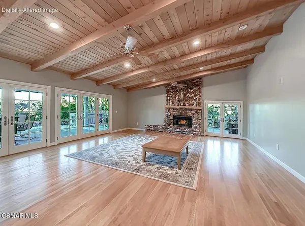 a view of a dining room and livingroom with furniture wooden floor a chandelier