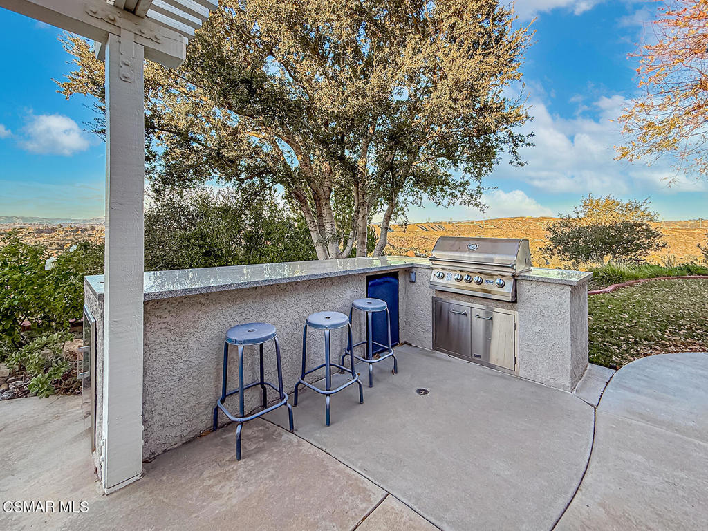 24525 Desert Avenue Newhall, CA 91321 - Photo 24 of 76 a view of a patio with a table and chairs under an umbrella
