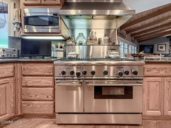 a living room with furniture kitchen view and a large window