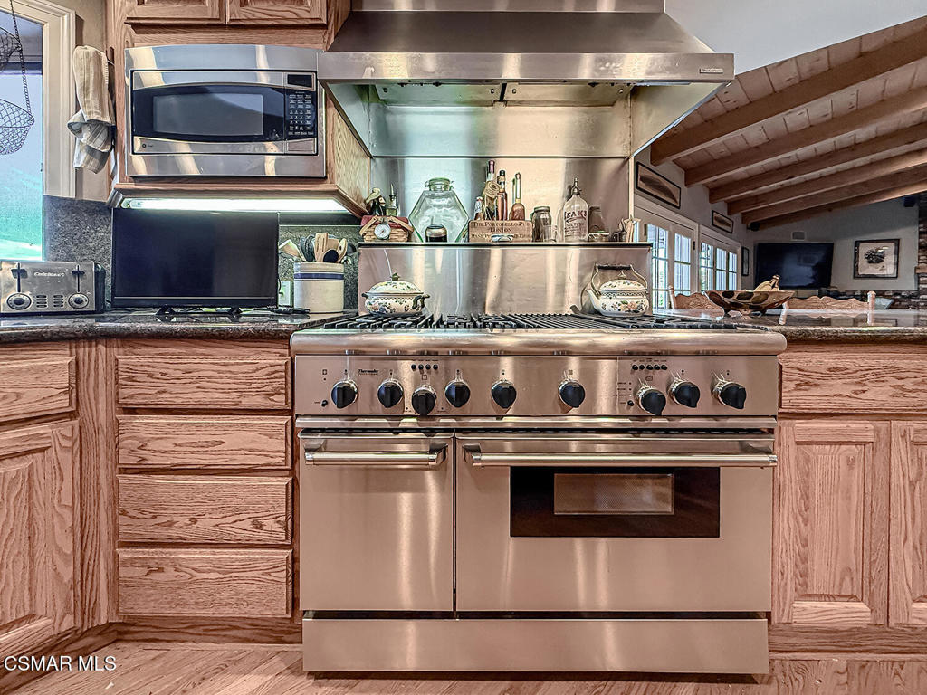 24525 Desert Avenue Newhall, CA 91321 - Photo 35 of 76 a kitchen with stainless steel appliances granite countertop a stove and a microwave