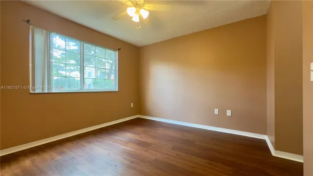an empty room with wooden floor cabinet and door