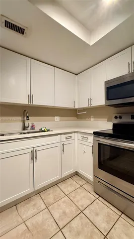 a kitchen with a refrigerator and a stove top oven