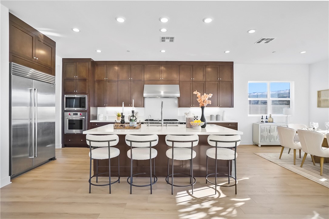 27392 Dialogue Way Valencia, CA 91381 - Photo 12 of 62 a dining room with stainless steel appliances kitchen island granite countertop a dining table chairs and a refrigerator