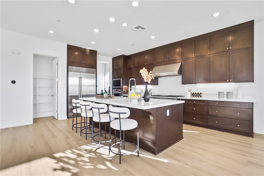 27392 Dialogue Way Valencia, CA 91381 - Photo 14 of 62 a kitchen with a island a sink stainless steel appliances and cabinets