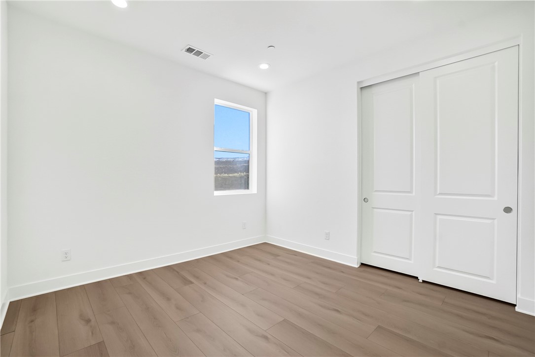 27392 Dialogue Way Valencia, CA 91381 - Photo 40 of 62 a view of an empty room with wooden floor