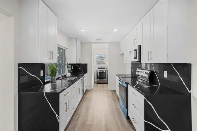 a kitchen with stainless steel appliances a sink and a stove top oven