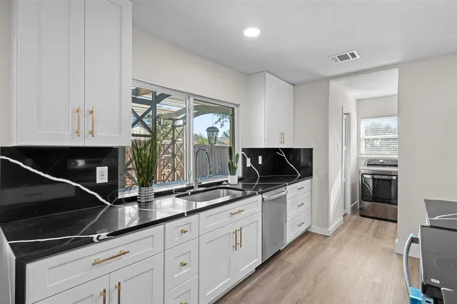 a kitchen with granite countertop a stove and a microwave