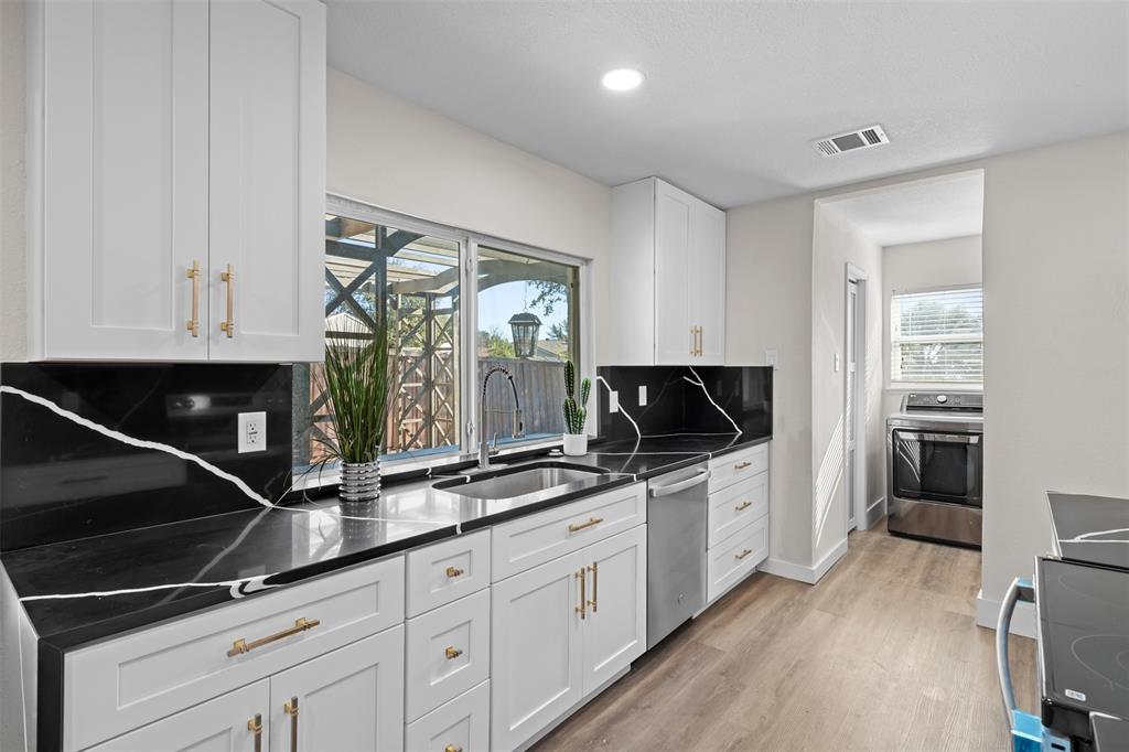 2008 East Peters Colony Road Carrollton, TX 75007 - Photo 13 of 35 a kitchen with stainless steel appliances a sink and a stove top oven