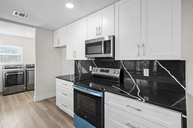 an empty room with wooden floor ceiling fan and windows