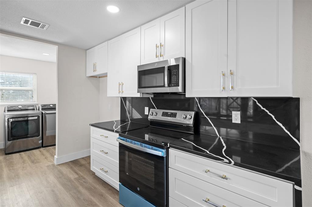 2008 East Peters Colony Road Carrollton, TX 75007 - Photo 14 of 35 a kitchen with granite countertop a stove and a microwave
