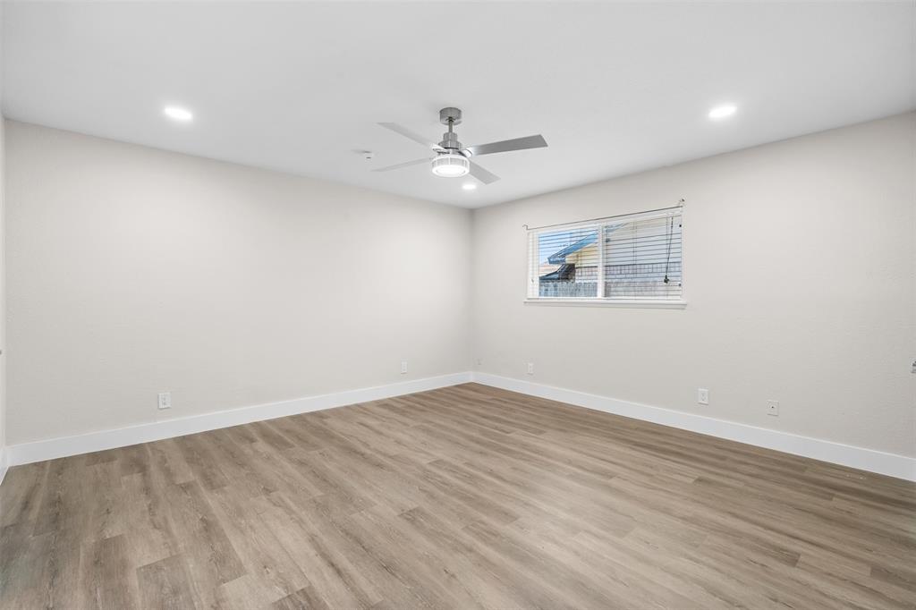 2008 East Peters Colony Road Carrollton, TX 75007 - Photo 15 of 35 an empty room with wooden floor ceiling fan and windows